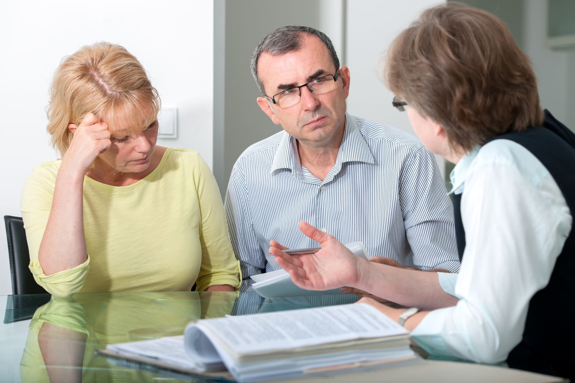 A concerned couple meeting with a legal professional to discuss nursing home issues and protect their loved one’s rights.